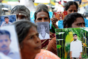 Sri Lankan Tamils hold pictures of family members who disappeared during the war between government forces and the Liberation Tigers of Tamil Eelam at a protest in Jaffna on November 15. (Reuters)